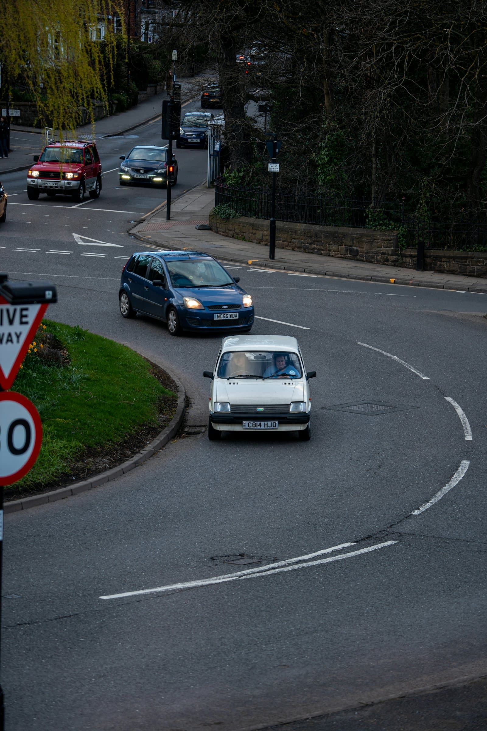 A learner car coming round a junction on a British street, a 30mph sign in the foreground